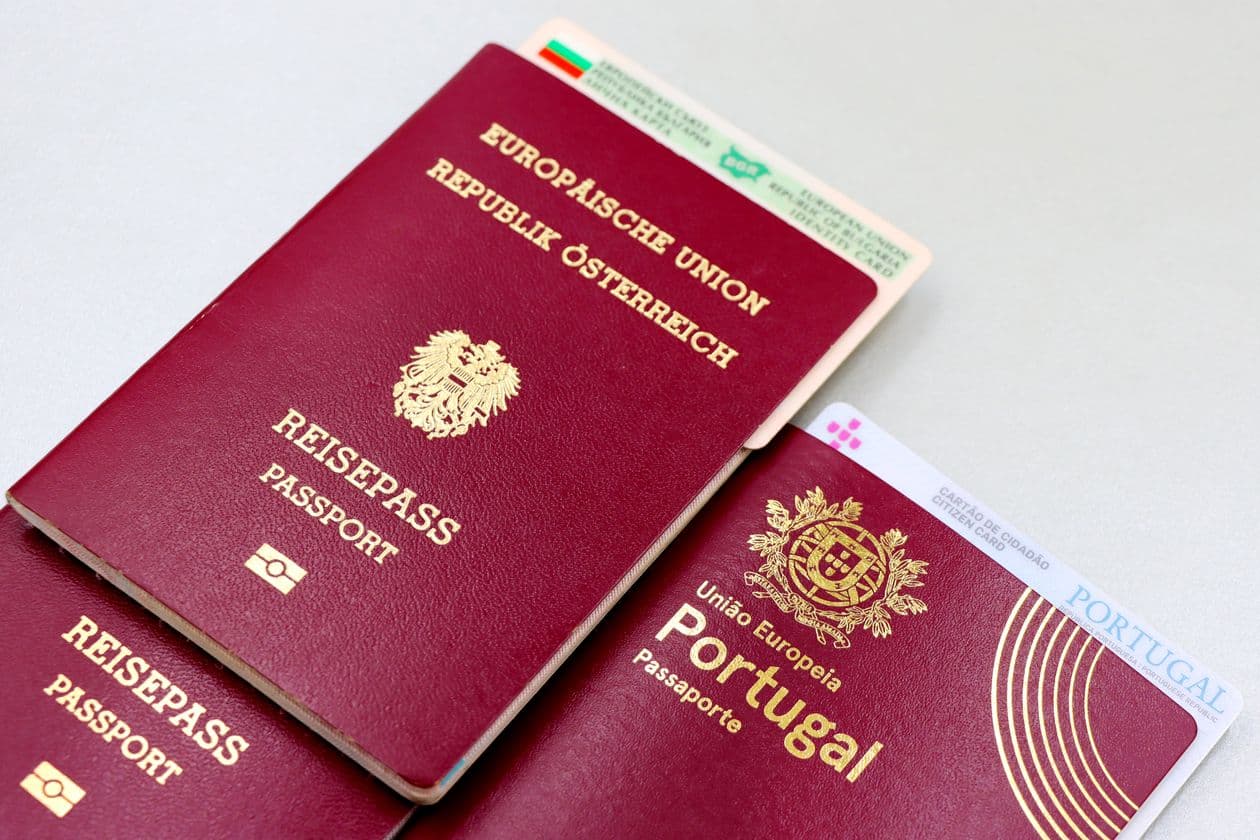 Close-up of Austrian and Portuguese passports next to a Bulgarian ID card, representing the different identity documents European sellers submit for Amazon KYC.